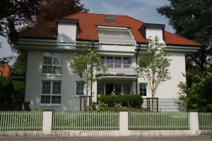 ein weißes Haus mit einem weißen Zaun davor in der Unterkunft Symphonie-Villa am See - Musikerviertel in Konstanz