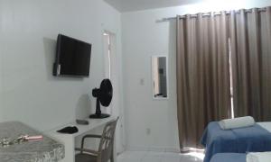 Habitación con cama y escritorio con TV. en Asa Norte, en Brasilia