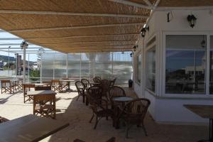 a restaurant with tables and chairs and a large window at Antonis Hotel in Kefalos
