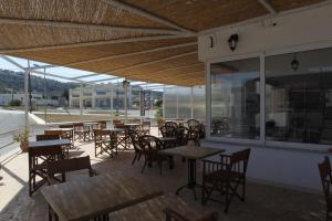 an empty restaurant with tables and chairs and windows at Antonis Hotel in Kefalos