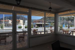 a room with windows and tables and chairs at Antonis Hotel in Kefalos