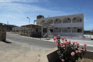 a building on the side of a road with flowers at Antonis Hotel in Kefalos