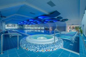 a swimming pool with a hot tub in a building at Holiday Home Čumar in Cerkno