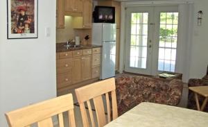 a kitchen with a couch and a table and a refrigerator at Inn On The Beach in Wasaga Beach