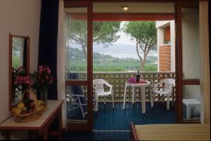 Cette chambre dispose d'un balcon avec une table et des chaises. dans l'établissement Hotel Marina 2, à Marina di Campo