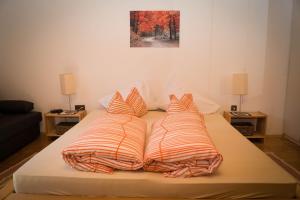 a bed with four pillows on it in a room at Egglmeier's Ferienwohnung in Grundlsee
