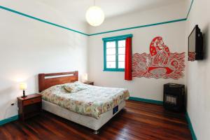 um quarto com uma cama e uma janela em Casa Violeta Limón em Valparaíso