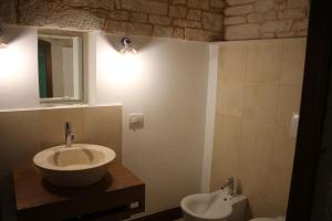 bagno con lavandino, specchio e servizi igienici di Tipico Suite ad Alberobello