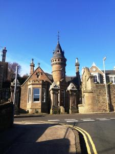 een oud huis met een toren erop bij Carbet Lodge in Dundee