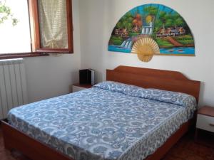 サバウディアにあるAfrodite Apartmentのベッドルーム1室(ベッド1台付)が備わります。壁には絵画が飾られています。