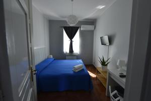 a bedroom with a blue bed and a window at Miss Sicily B&B in Terrasini