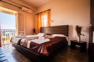 a bedroom with a large bed and a balcony at Ulrika in Egina