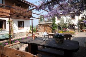 patio z drewnianym stołem i fioletowymi kwiatami w obiekcie Cascina Bricco w mieście Ovada