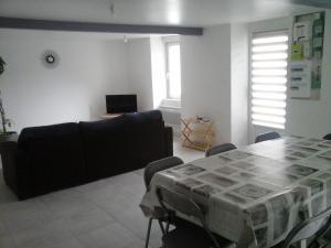 a living room with a table and a couch at Maison au calme in Vezins