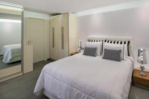 a hotel room with a bed and a dresser at Elea Resort - Adults Only in Oia