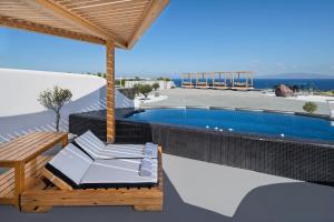 a villa with a swimming pool and a table and chairs at Elea Resort - Adults Only in Oia