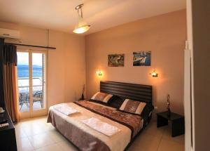 a bedroom with a bed with a view of the ocean at Plaza in Egina