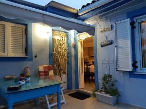 Casa azul con mesa azul y comedor en Kallithea Holiday Homes, en Kallithea