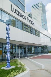 a street sign in front of a large building at Hotel Luzeiros Recife in Recife
