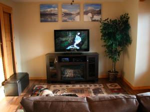 a living room with a couch and a flat screen tv at Montana Style Downtown Condo in Whitefish