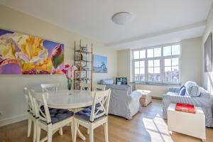 a living room with a table and chairs at Res. Golf Zoute in Knokke-Heist