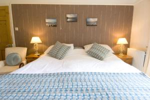 a bedroom with a large white bed with two pillows at Gogarth hall Farm holidays in Pennal