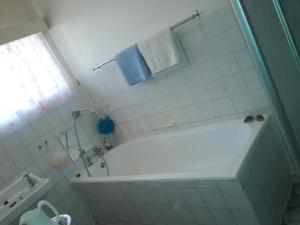 a white bathroom with a tub and a shower at Heila's in house Family room-Homestay! in Bloemfontein
