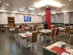 a dining room with tables and chairs and a screen at Hotel Alcala in David