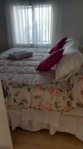 a bed with pillows on top of it with a window at Casa Langla Lunahuana in Lunahuaná