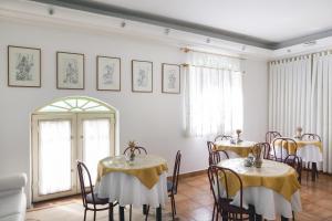 a dining room with two tables with yellow table cloth at Hotel Casablanca in Campinas