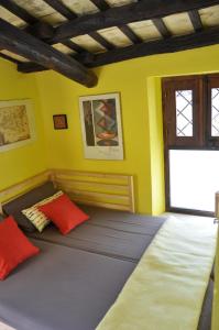 エーリチェにあるAppartamentino Pomeliaのベッドルーム1室(オレンジ色の枕と窓付)