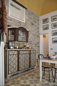 uma cozinha com um balcão e uma mesa com cadeiras em Case Bruno Residenze Tipiche em Erice