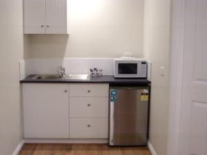 a small kitchen with a microwave and a refrigerator at Ruby Rose in Simpson