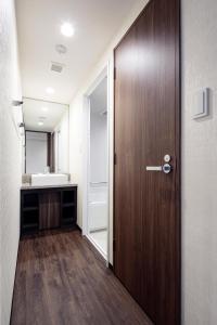 a bathroom with a wooden door and a sink at Hotel Mystays Premier Akasaka in Tokyo +37 photos
