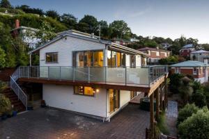 ein großes weißes Haus mit Balkon darüber in der Unterkunft Sleep on the Steepest Street in the World! in Dunedin