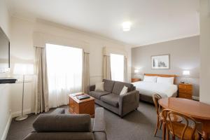 a hotel room with a bed and a table at Majestic Tynte Street Apartments in Adelaide