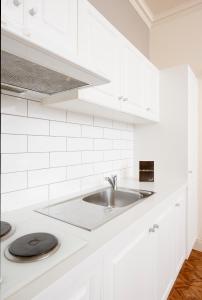 eine Küche mit weißen Schränken und einem Waschbecken in der Unterkunft Majestic Tynte Street Apartments in Adelaide
