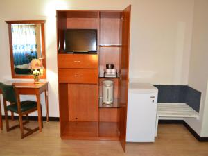 a room with a small kitchen with a microwave and a television at West Plaza Downtown in Koror