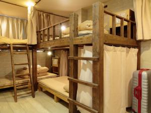 a bunk bed room with two bunk beds and a suitcase at Kyoto Hana Hostel in Kyoto