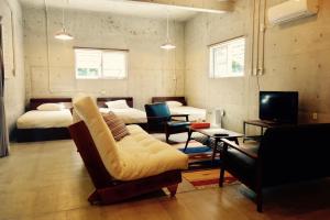 Habitación con 2 camas, sofá y TV. en Retya en Isla Ishigaki