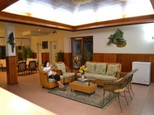 a woman sitting on a couch in a living room at West Plaza Downtown in Koror