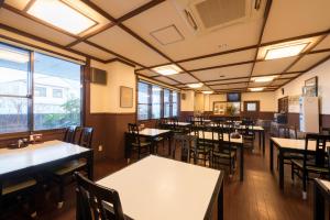 十和田都田市酒店 的有桌椅和窗户的餐厅