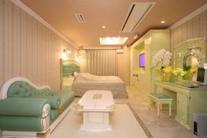 a bedroom with a bed and a couch and a table at Hotel AtoZ Saku (Adult Only) in Saku