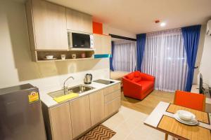 a kitchen with a sink and a red chair at Centrio by Suttirak in Phuket