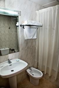 a bathroom with a sink and a toilet and a mirror at Hotel La Piqueta in Benasal