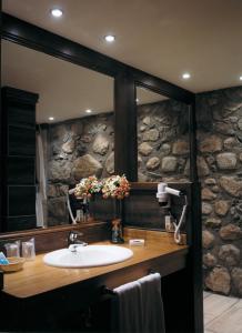 a bathroom with a sink and a stone wall at Hotel Hospital de Benasque in Benasque