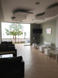 a lobby with couches and tables and a television at Villa Un bel posto Sea View in Nea Vrasna