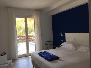 a bedroom with a bed and a sliding glass door at Arli Hotel Hideaway Punta Ala - Adults Only in Punta Ala