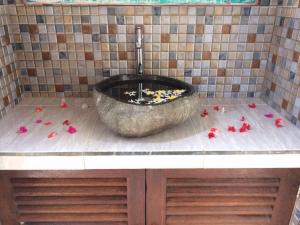 a bathroom with a large bowl sink with flowers on the floor at Karimun Lumbung in Karimunjawa
