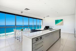 
a kitchen with a large window overlooking the ocean at ULTIQA Air On Broadbeach in Gold Coast

